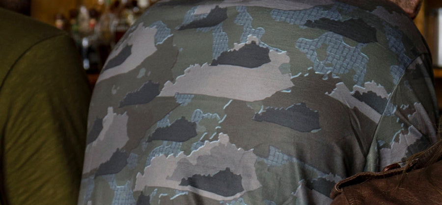 Man leaning against bar wearing Kentucky State Camo long sleeve shirt