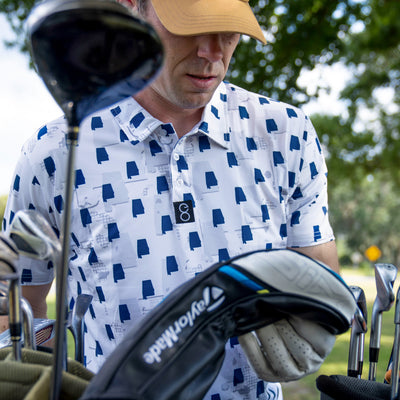 Man holding golf club wearing Auburn Tigers Camo Gameday Men's performance Polo