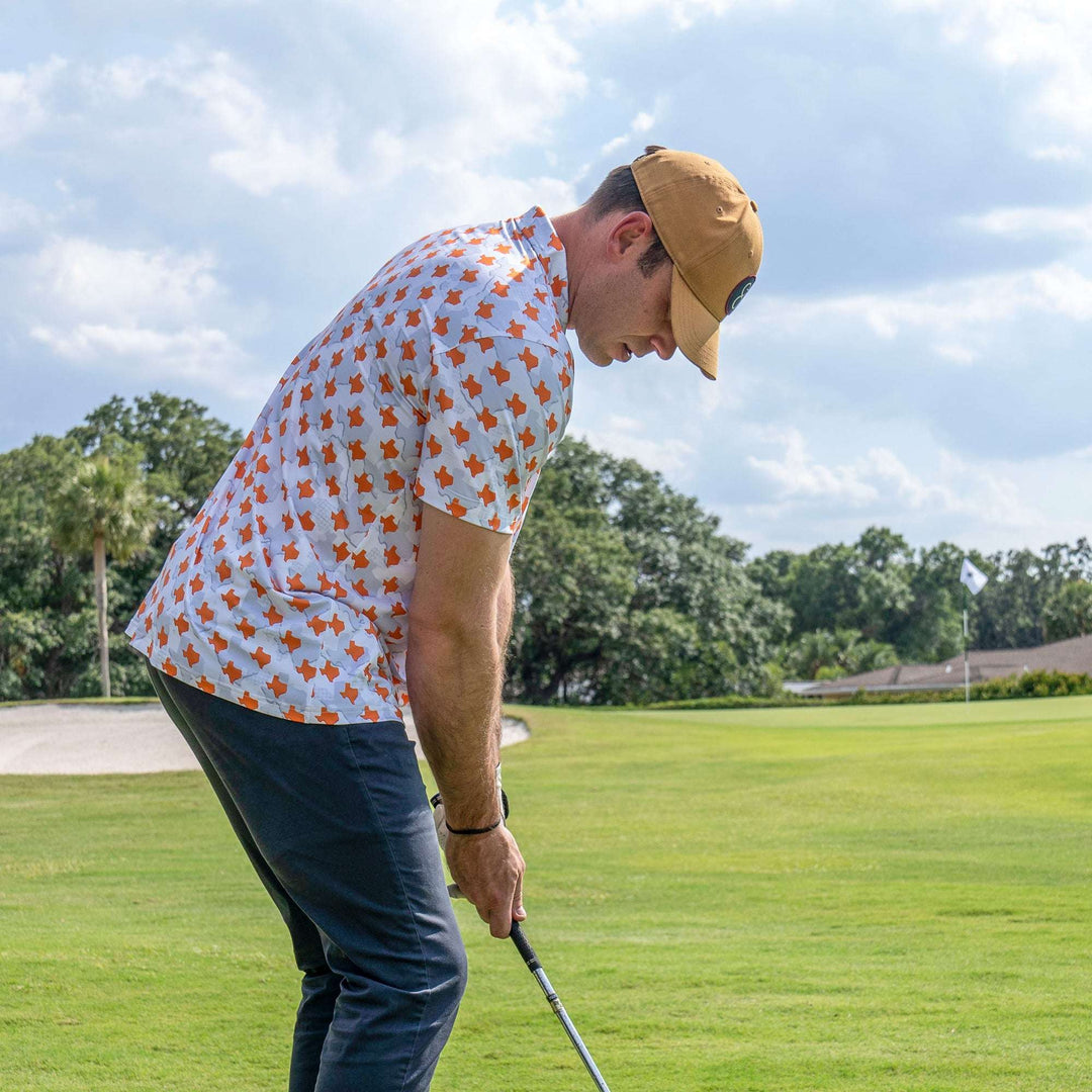 Man playing golf wearing Texas Longhorn Camo Gameday Men's performance Polo