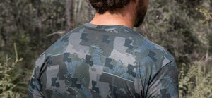 Man walking in woods wearing Louisiana State Camo long sleeve shirt