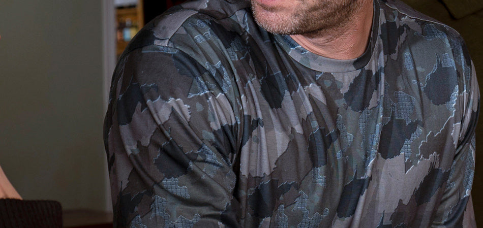 Man leaning on bar wearing West Virginia State Camo long sleeve shirt