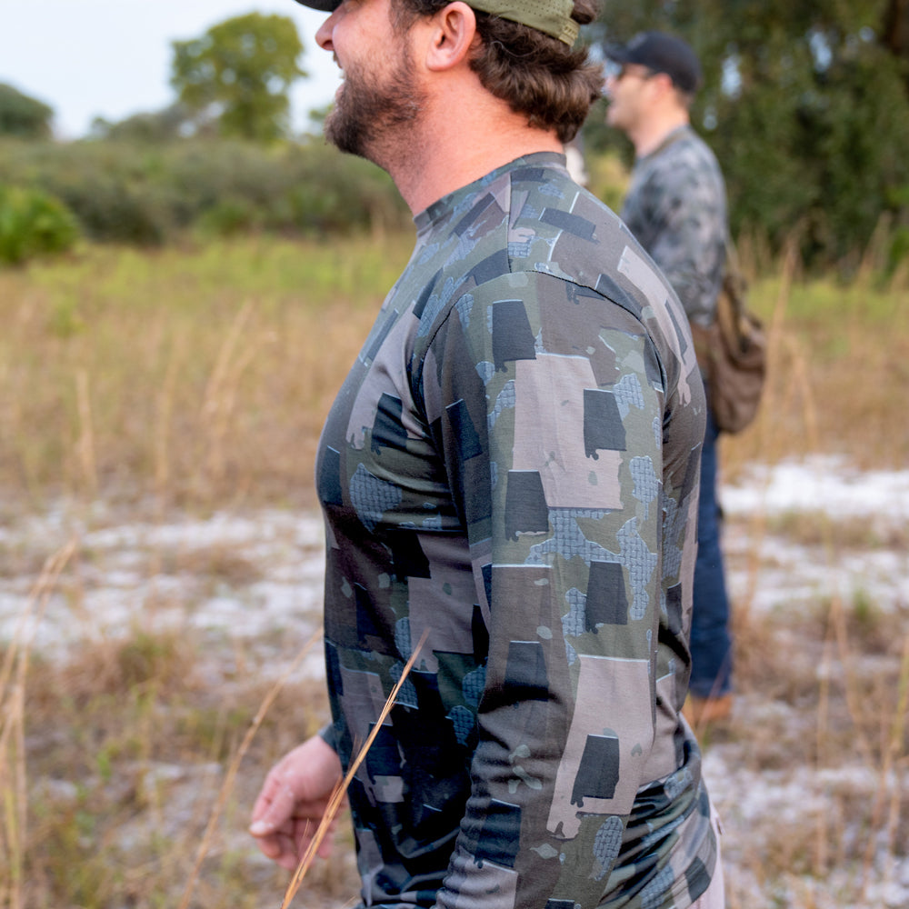 Man walking in field wearing men's Alabama camo long sleeve shirt