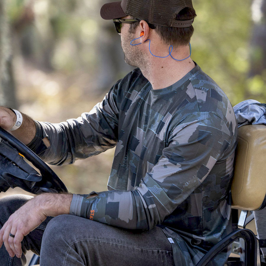 Man in a golf cart wearing Everyday Outdoors Arkansas State Camo long sleeve shirt