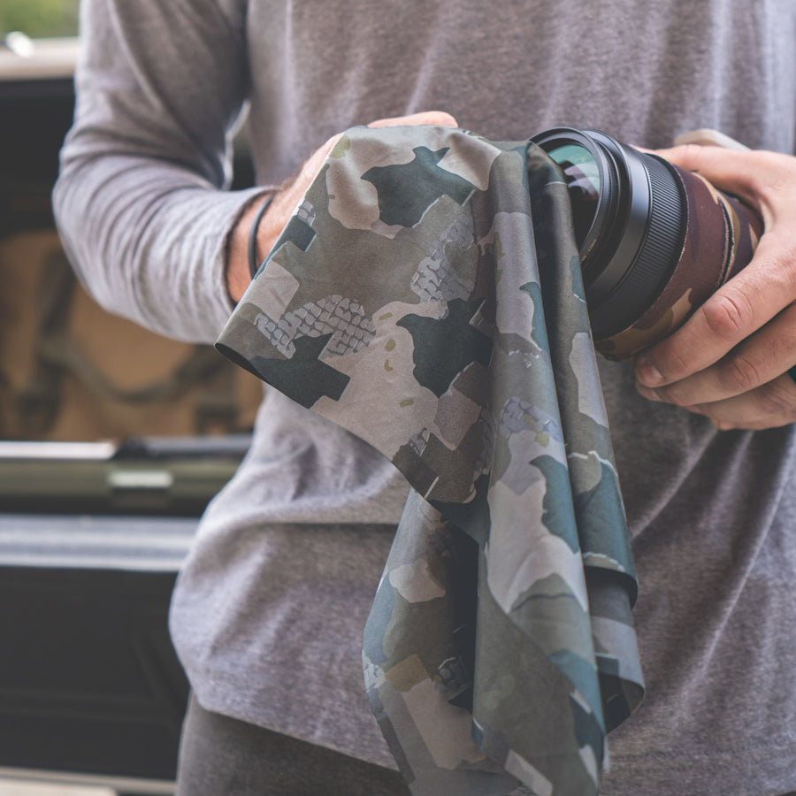 Man cleaning Camera lens with Texas Camo microfiber field towel - Everyday Outdoors.