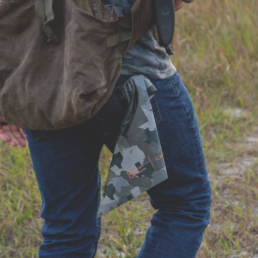 Man walking in field with Texas Camo microfiber field towel - Everyday Outdoors.